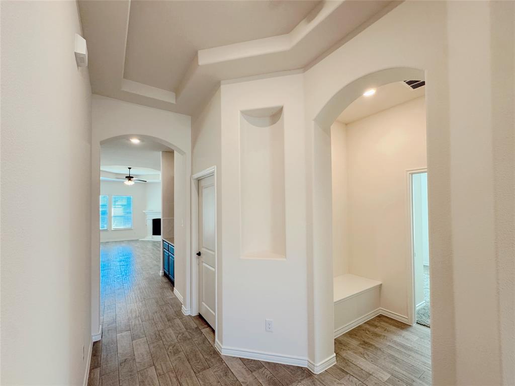 1076 Sublime Drive Forney, TX 75126 - Photo 10 of 40 a view of a hallway with wooden floor and a bathroom