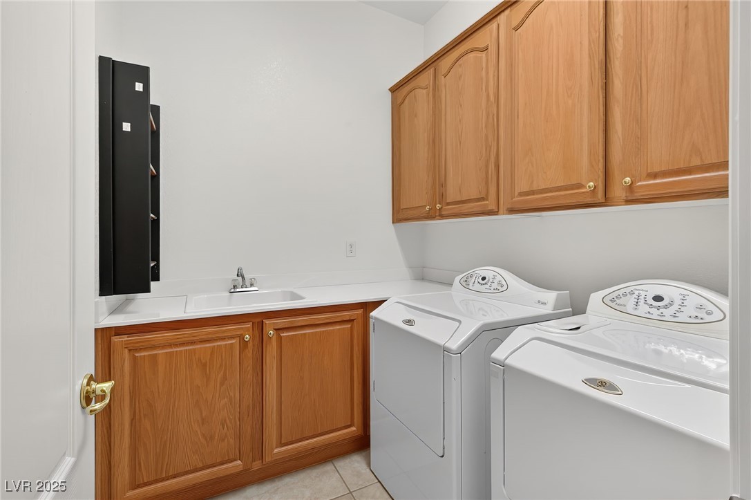 1028 Triumphant Street Henderson, NV 89052 - Photo 27 of 51 Laundry area featuring washer and dryer, cabinet space, and light tile patterned flooring