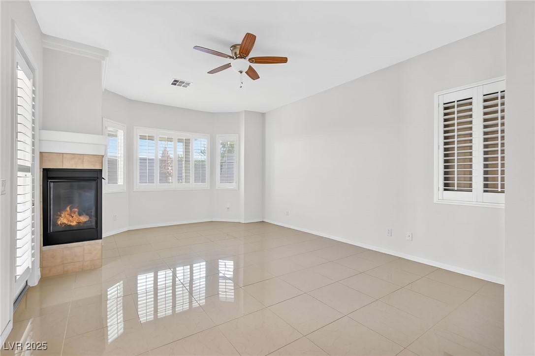 1028 Triumphant Street Henderson, NV 89052 - Photo 29 of 51 Master Bedroom with a tiled fireplace, light tile patterned flooring, and ceiling fan