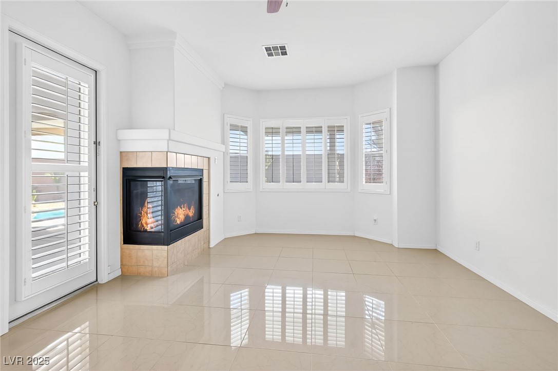 1028 Triumphant Street Henderson, NV 89052 - Photo 30 of 51 Master Bedroom featuring a tile fireplace, light tile patterned flooring, and ceiling fan