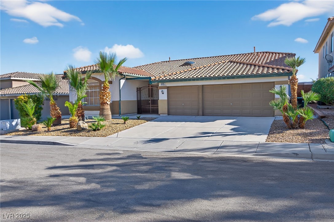1028 Triumphant Street Henderson, NV 89052 - Photo 3 of 51 Mediterranean / spanish house with driveway, stucco siding, a tile roof, and an attached garage