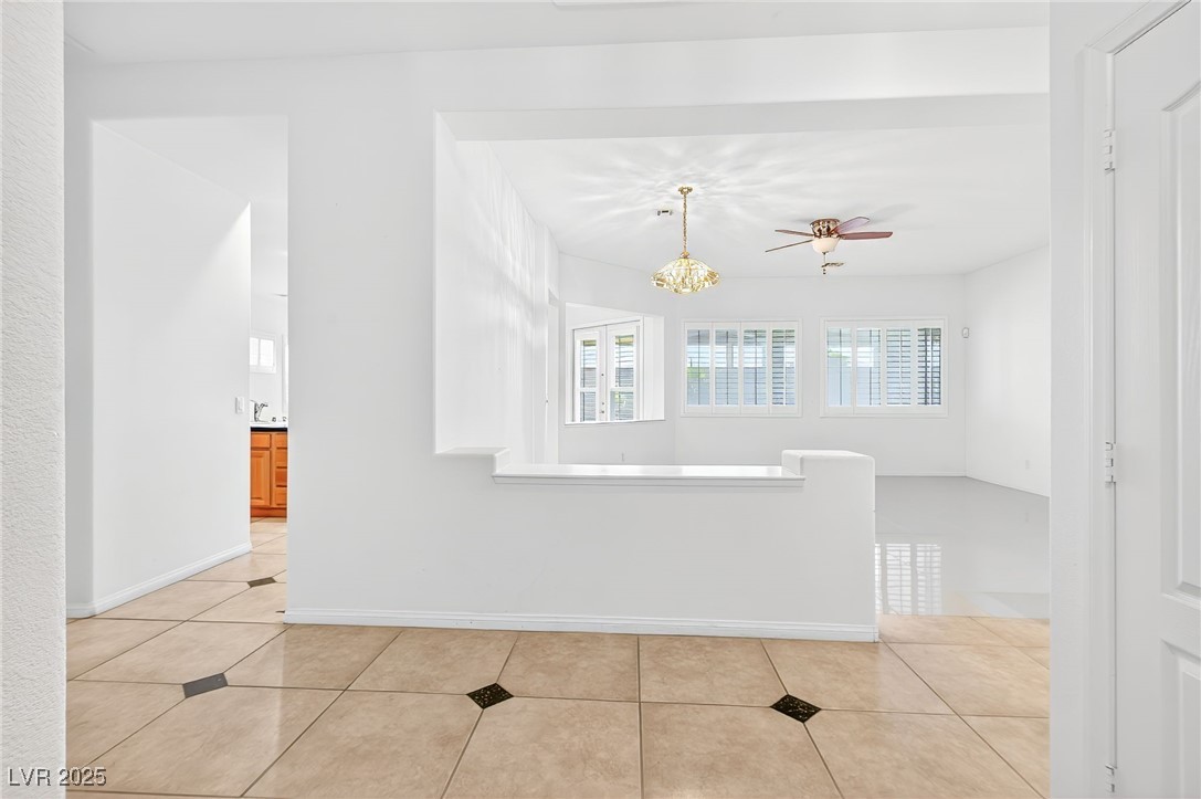 1028 Triumphant Street Henderson, NV 89052 - Photo 7 of 51 Entry featuring light tile patterned flooring, a chandelier, and ceiling fan