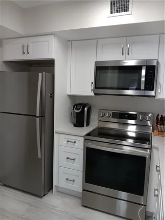 a kitchen with stainless steel appliances wooden cabinets and stove