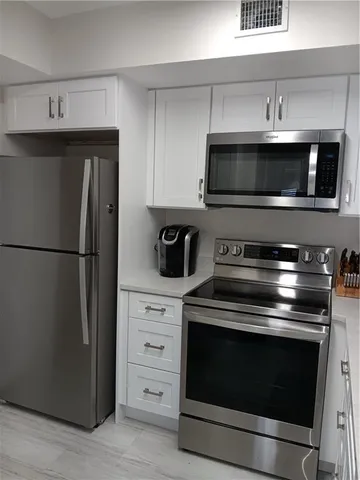 a kitchen with stainless steel appliances wooden cabinets and stove
