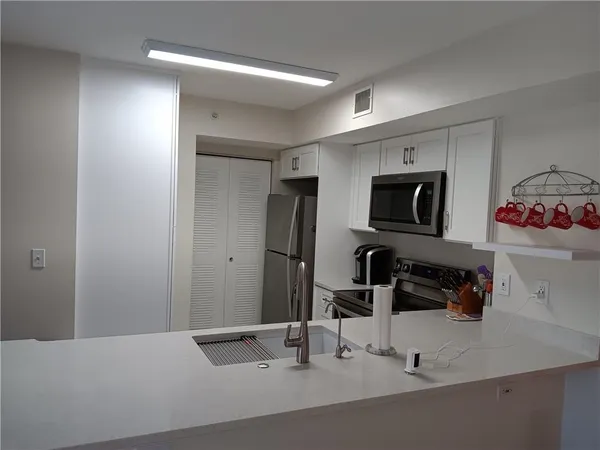 a kitchen with a sink a counter and appliances