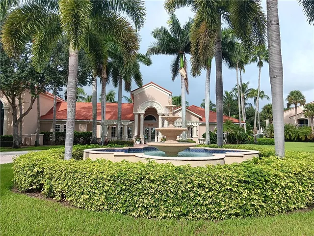 a front view of a house with a garden and trees