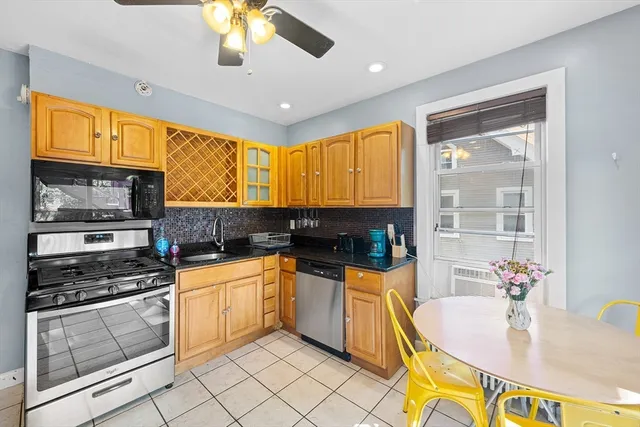 a kitchen with stainless steel appliances granite countertop a stove a sink and a microwave