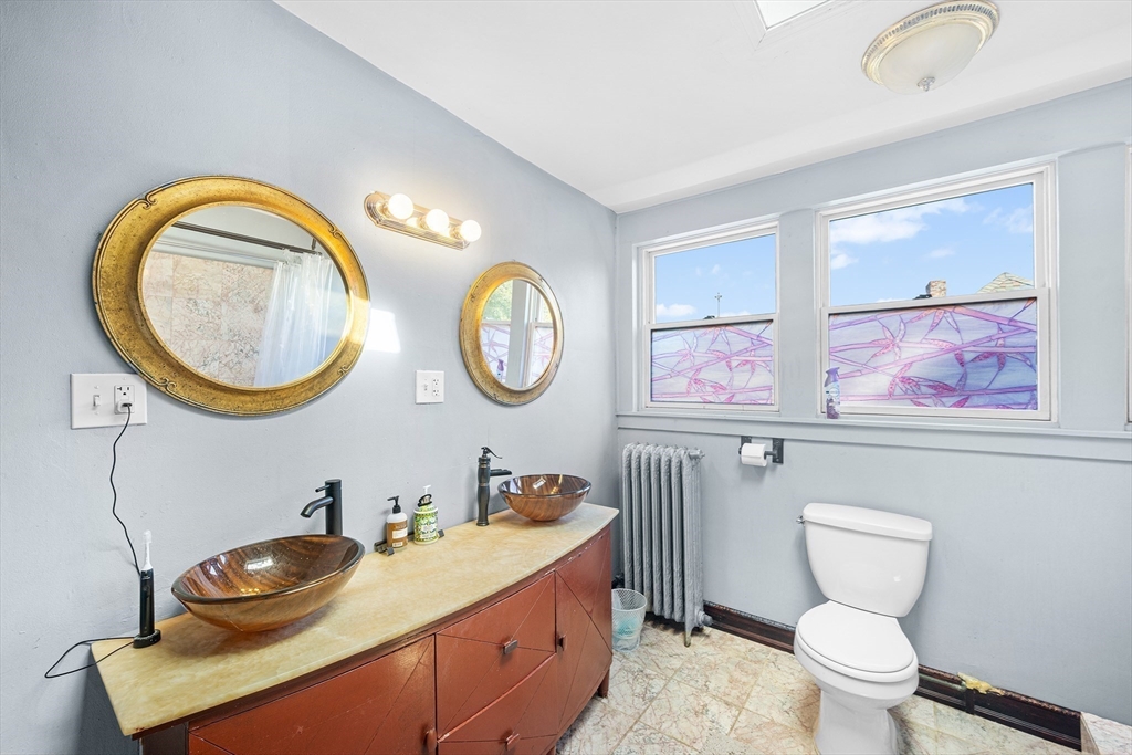 16 Mayfair Street Boston, MA 02119 - Photo 24 of 36 a bathroom with a toilet a sink and a mirror