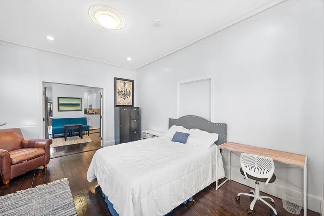 a bedroom with a bed and wooden floor