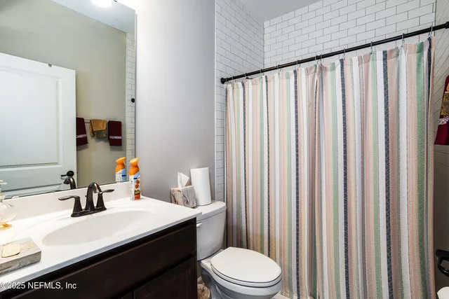 a bathroom with a sink a toilet and shower curtain