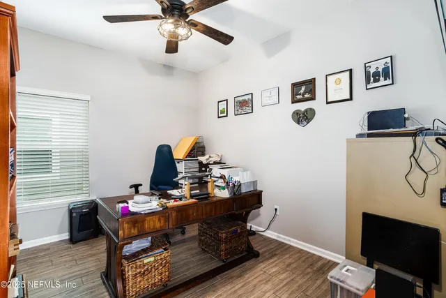 a room with chandelier fan and wooden floor