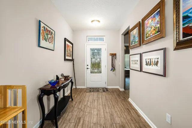 a view of a hallway with wooden floor and a workspace