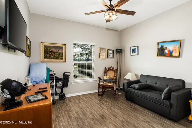 a living room with furniture a flat screen tv and a window