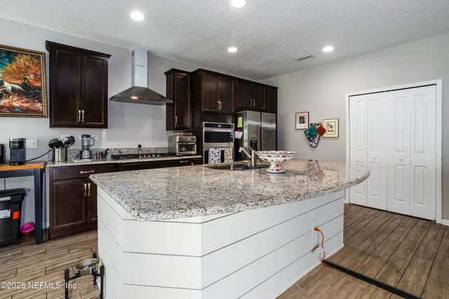 a kitchen with stainless steel appliances granite countertop a sink stove and cabinets