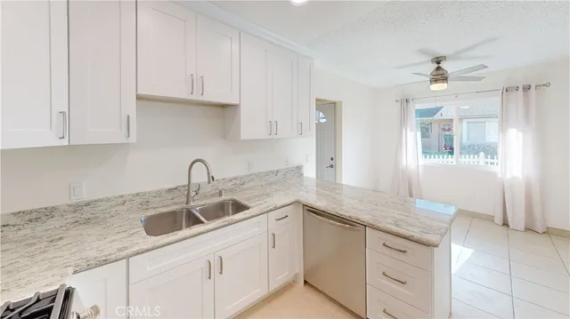 a kitchen with granite countertop a sink dishwasher and cabinets