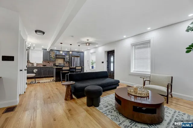 a living room with furniture and a view of kitchen