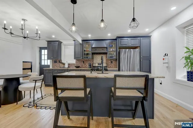 a kitchen with kitchen island a dining table chairs sink and cabinets