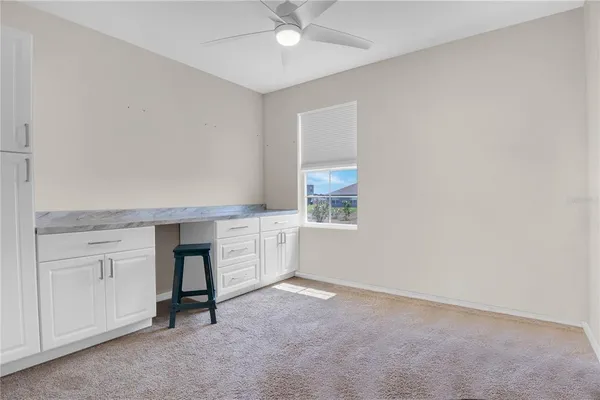 an empty room with windows and fan