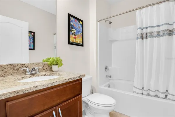 a bathroom with a granite countertop sink mirror vanity and toilet