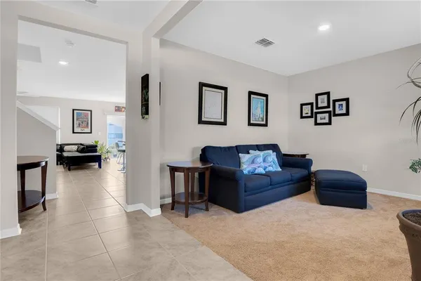 a living room with furniture and a refrigerator