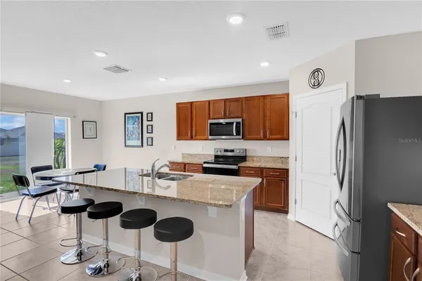 a kitchen with stainless steel appliances granite countertop a refrigerator and a stove top oven