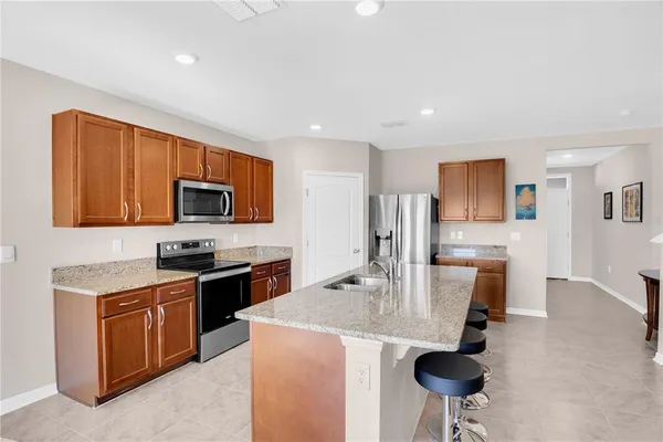 a kitchen with stainless steel appliances granite countertop a sink a stove top oven a counter space and cabinets