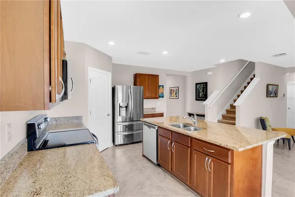 a kitchen with sink refrigerator and stove