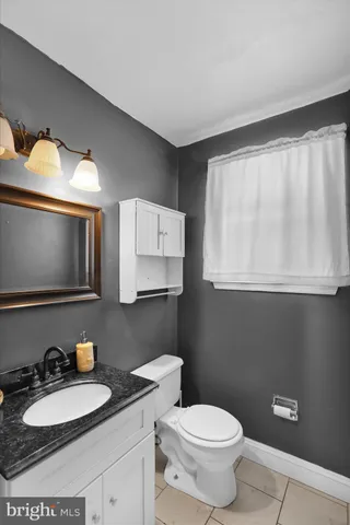 a bathroom with a toilet a sink and mirror