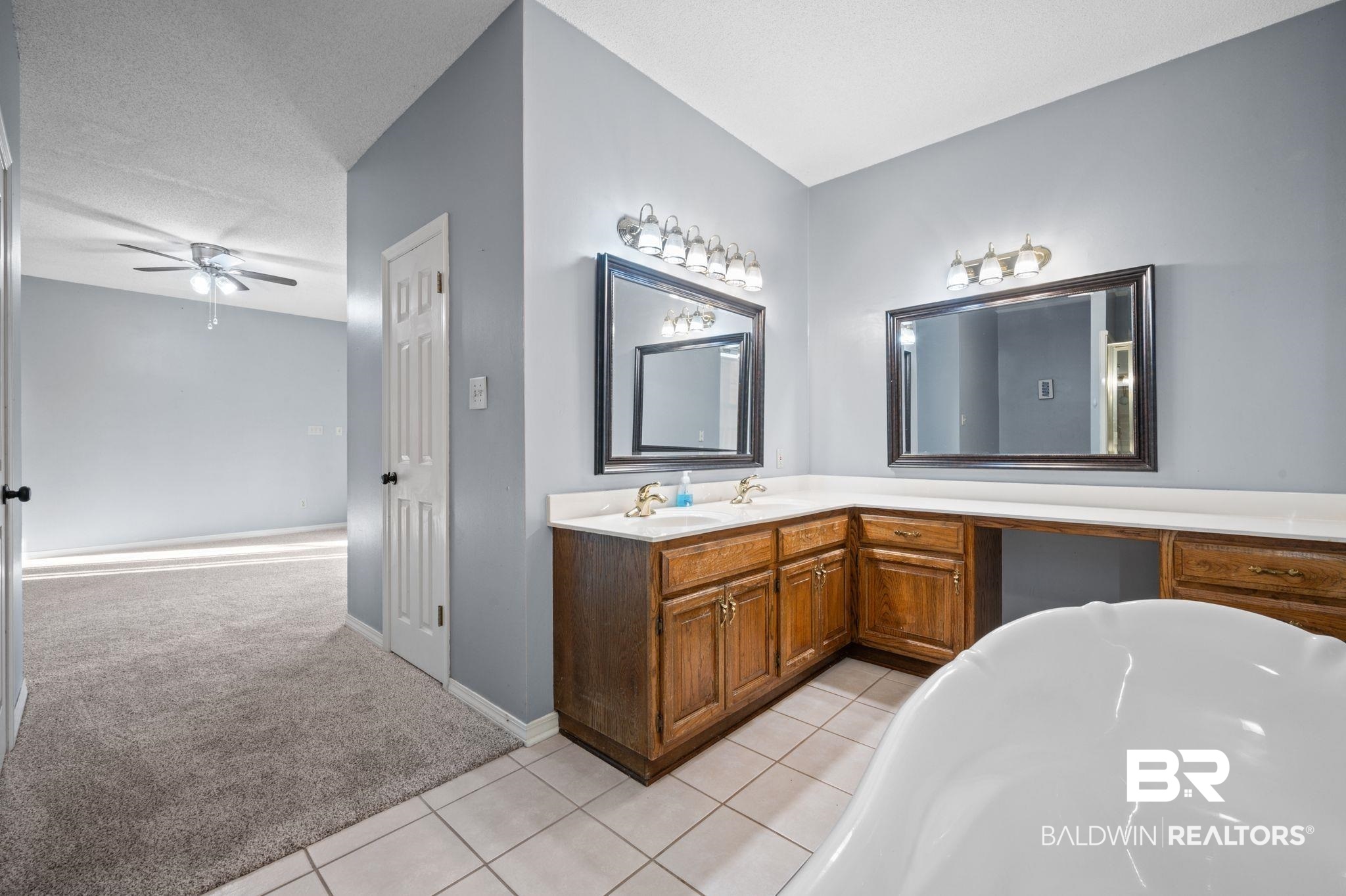 100 Orleans Way Daphne, AL 36526 - Photo 23 of 31 Bathroom with vanity, tile patterned flooring, ceiling fan, a textured ceiling, and a tub