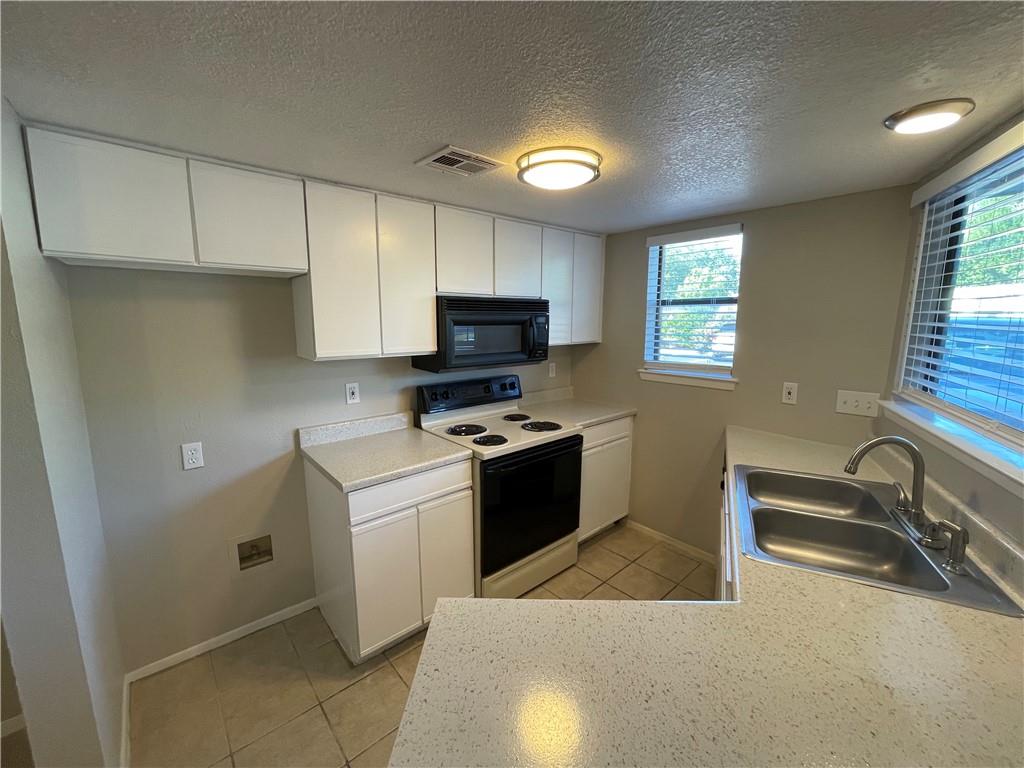 a kitchen with a stove a sink and a microwave