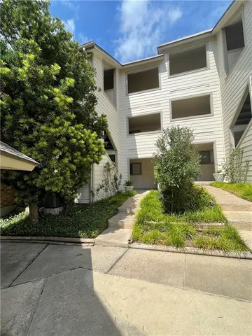 a white building with a big yard and large trees