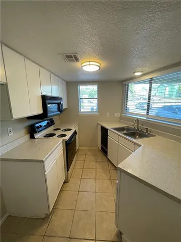 a kitchen with stainless steel appliances a sink stove and cabinets