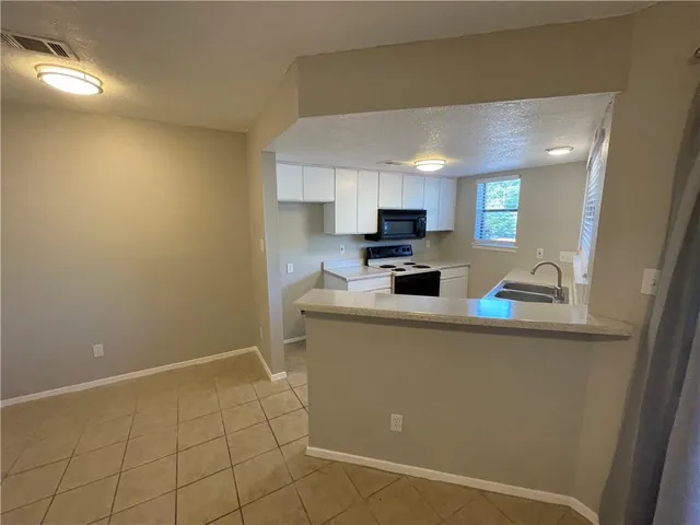 a open kitchen with cabinets and a sink