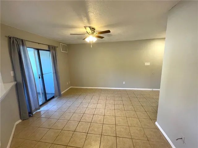 a view of an empty room and window chandelier fan
