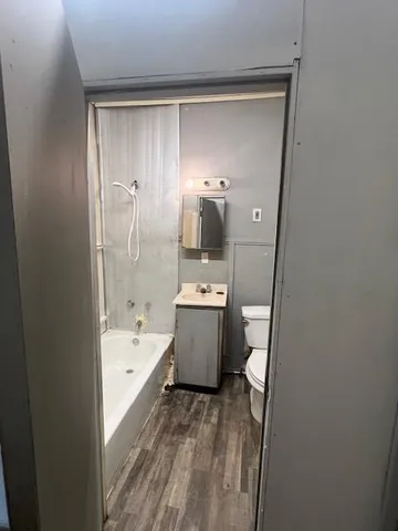 a bathroom with a tub sink and mirror