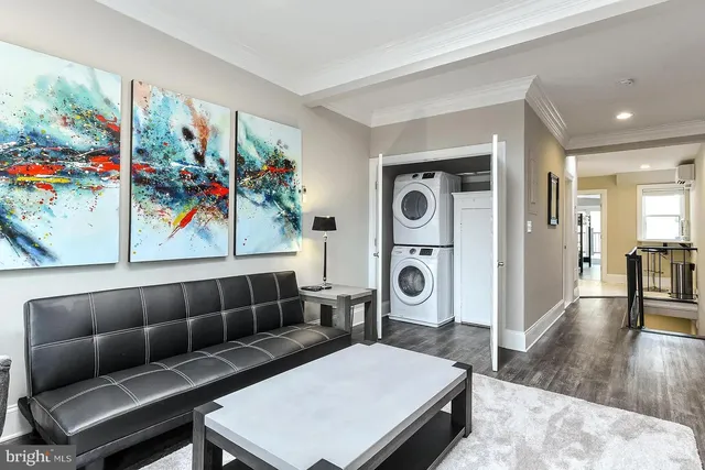 a living room with furniture a flat screen tv and a floor to ceiling window