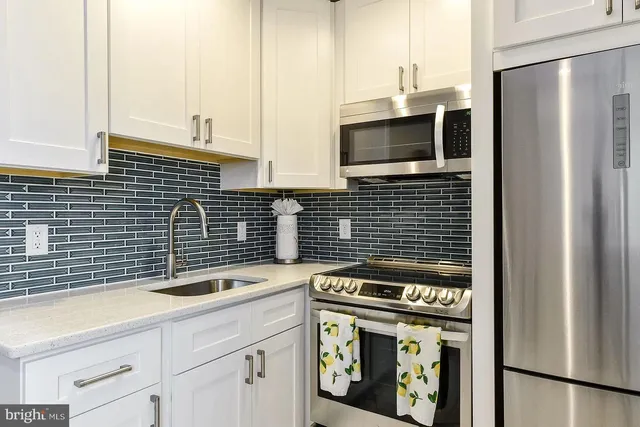 a kitchen with granite countertop a sink stove and refrigerator