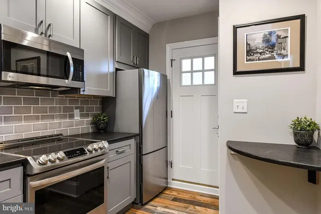 a kitchen with stainless steel appliances and microwave