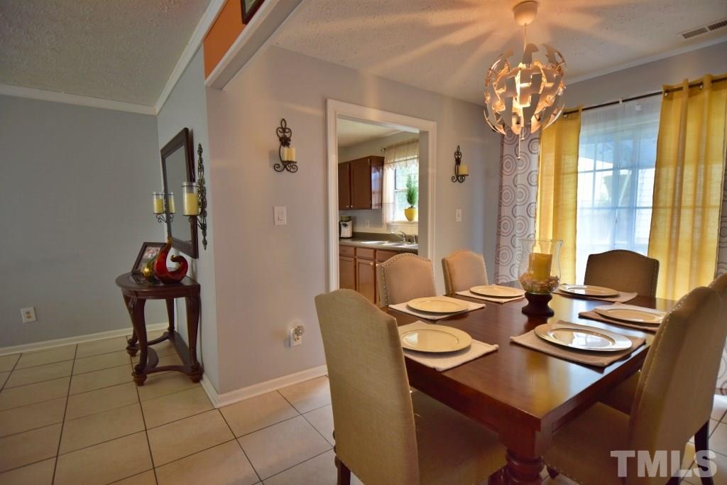8301 Wynewood Court Raleigh, NC 27616 - Photo 14 of 22 a view of a dining room with furniture and a chandelier