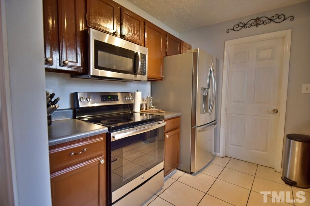 8301 Wynewood Court Raleigh, NC 27616 - Photo 15 of 22 a kitchen with stainless steel appliances granite countertop a stove microwave and refrigerator
