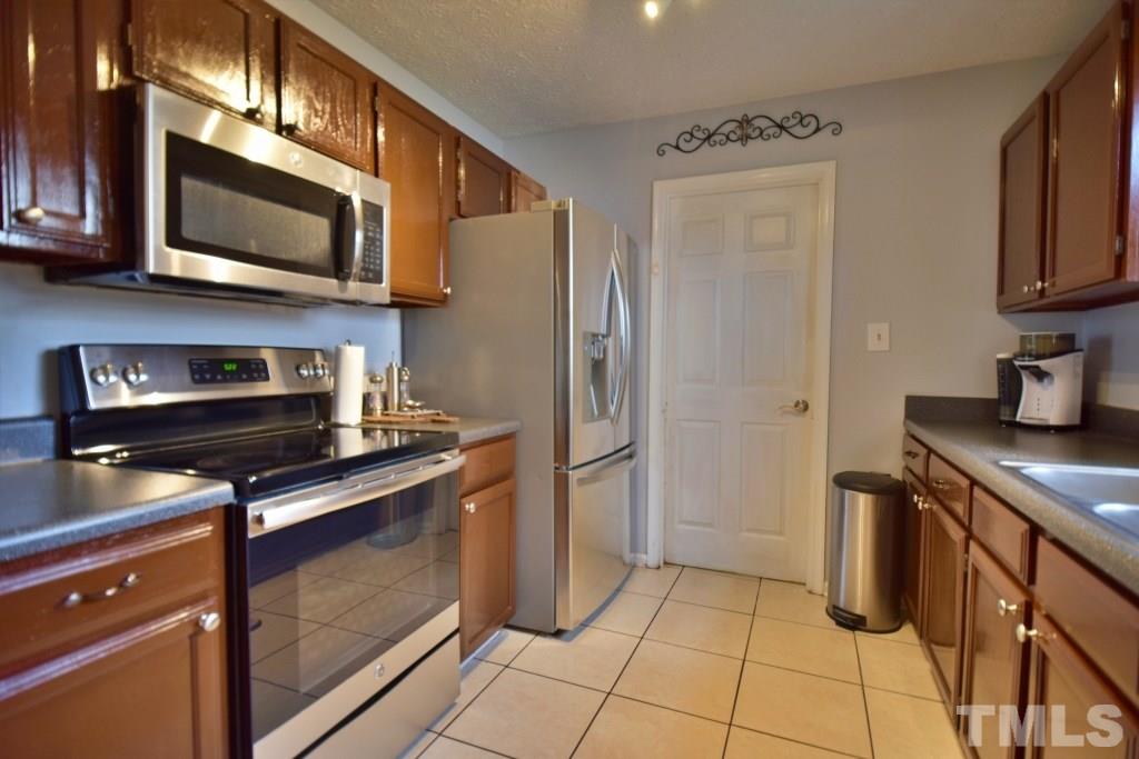 8301 Wynewood Court Raleigh, NC 27616 - Photo 16 of 22 a kitchen with stainless steel appliances granite countertop a stove microwave and refrigerator