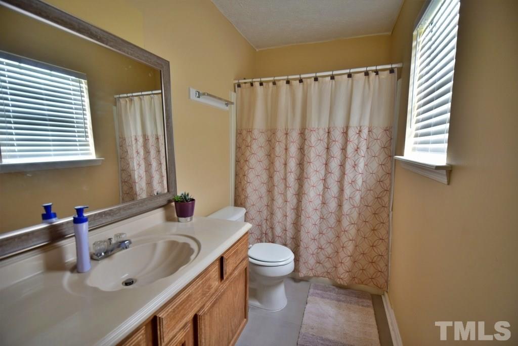 8301 Wynewood Court Raleigh, NC 27616 - Photo 18 of 22 a bathroom with a sink a toilet and shower curtain