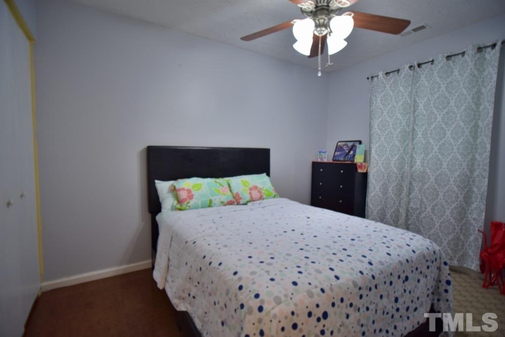 8301 Wynewood Court Raleigh, NC 27616 - Photo 20 of 22 a bedroom with a bed and a chandelier