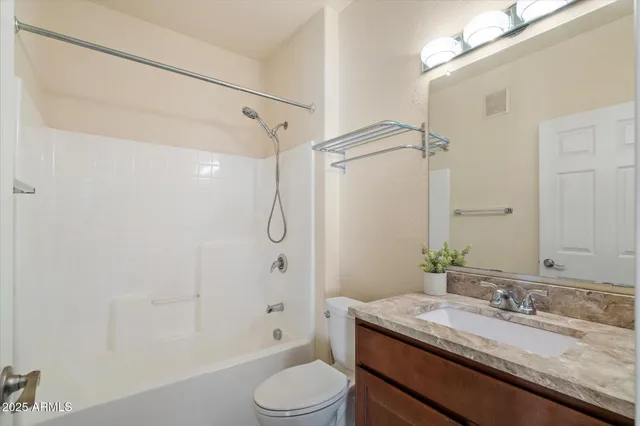 a bathroom with a granite countertop sink toilet a shower and a mirror