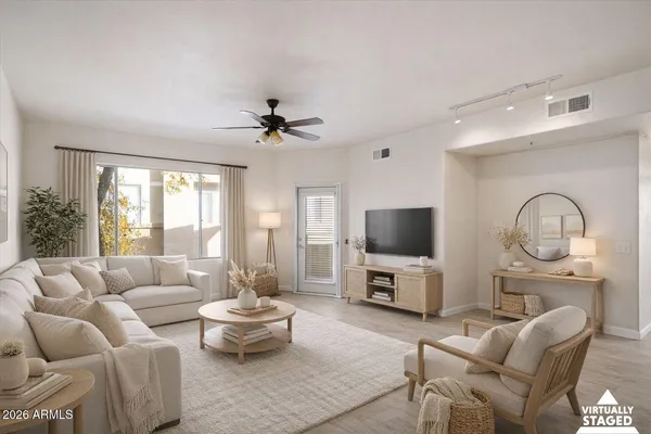 a living room with furniture a flat screen tv and a large window