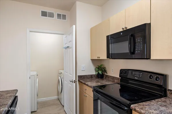 a kitchen with stainless steel appliances granite countertop a stove a sink and a refrigerator