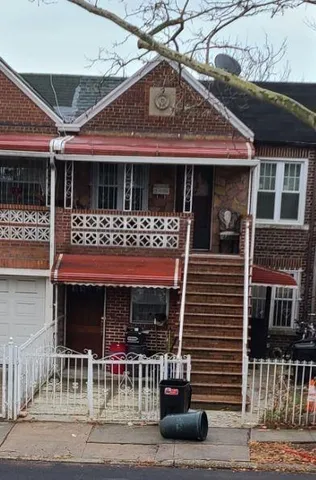 a front view of a house with glass windows and a table and chairs