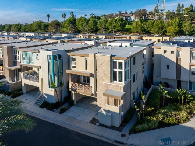 an aerial view of residential houses with outdoor space and parking