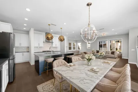 a living room with furniture kitchen view and a chandelier