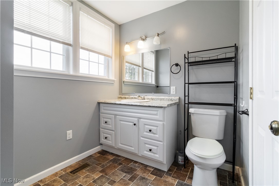 57459 Shry Road Barnesville, OH 43713 - Photo 17 of 44 Half bathroom featuring stone finish floors and vanity